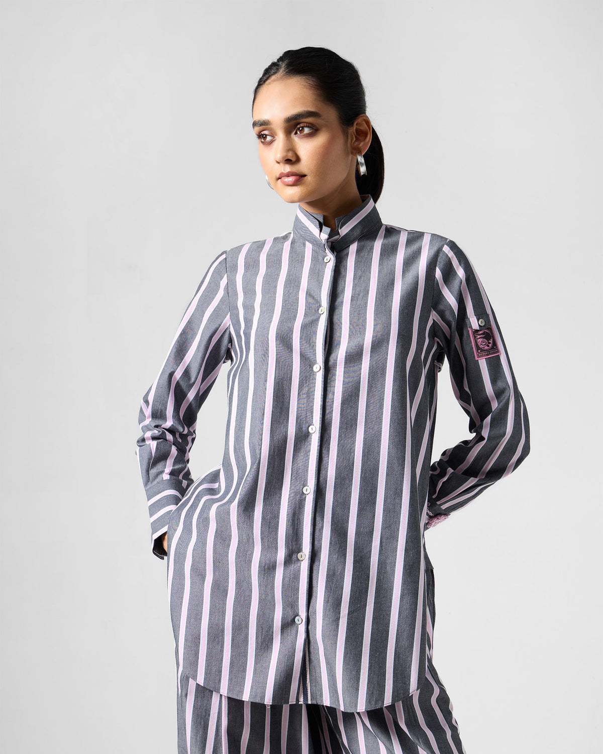 Person wearing a charcoal and pink striped Trench shirt set.