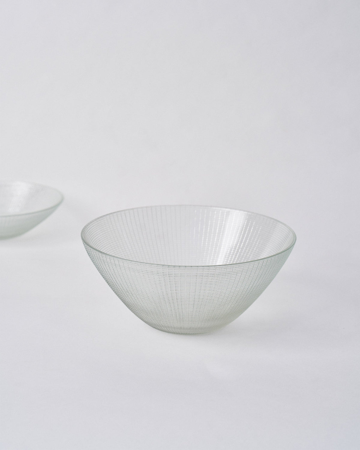 Three-quarter view of Aire Serving Bowl in clear, fine-ridged glass.