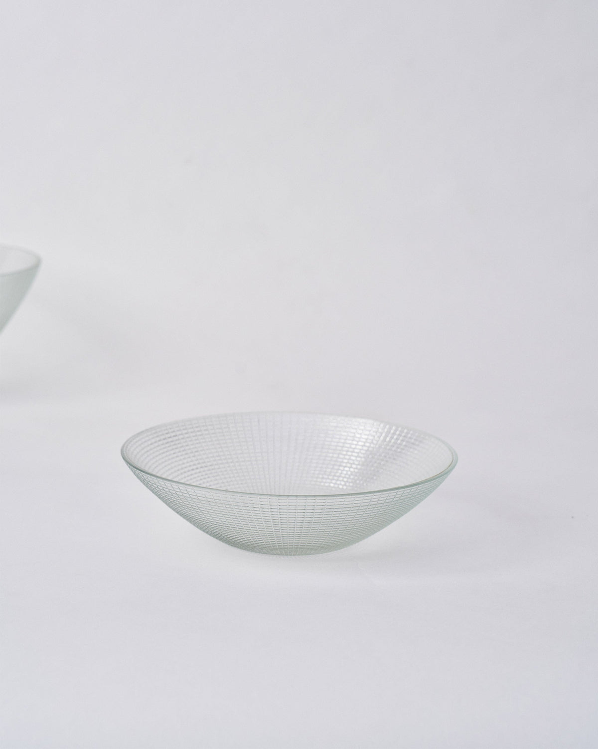 Shallow clear Aire serving bowl showing its flared rim and grid texture.