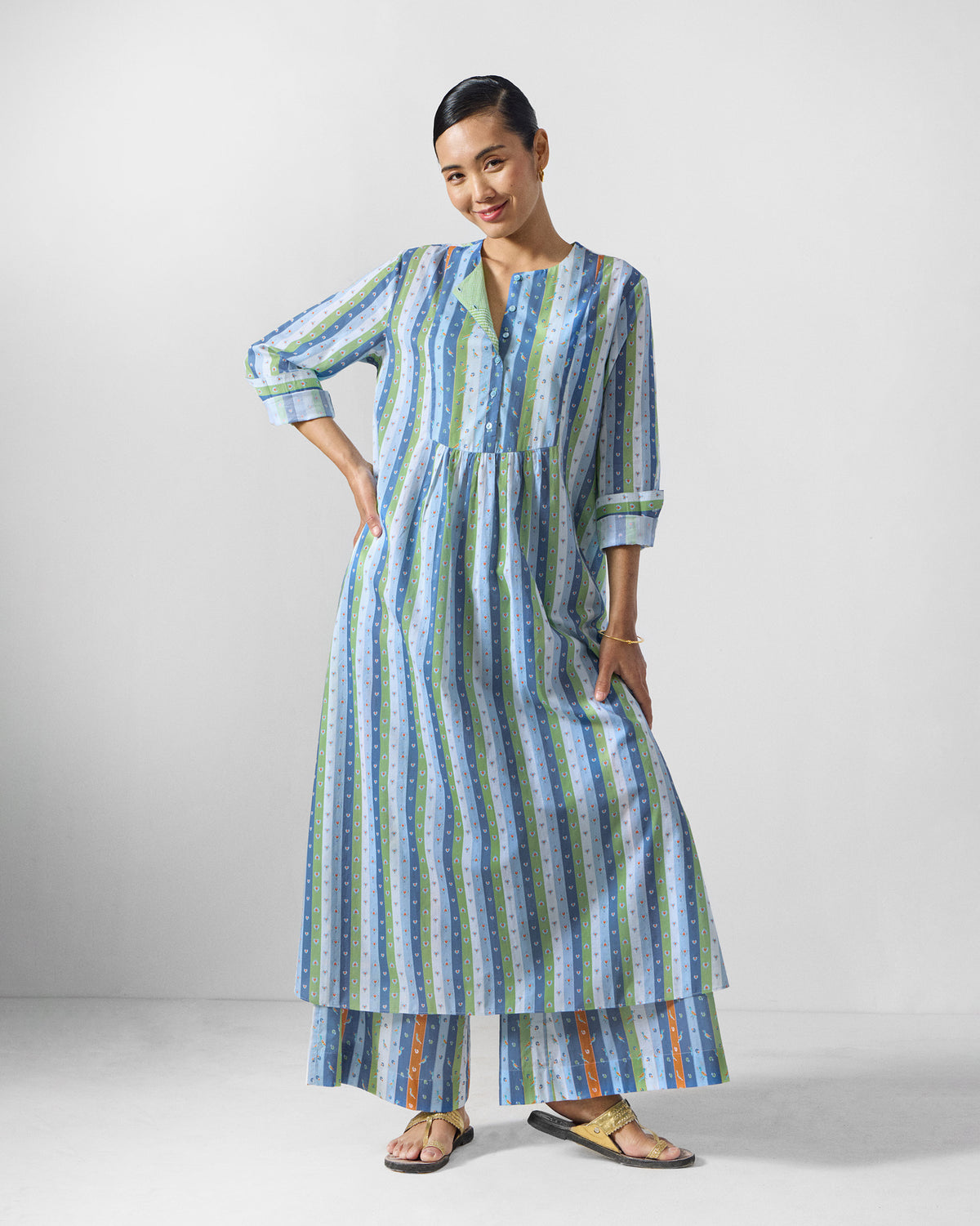 Person wearing the Imke kurta set in blue and green stripes with cuffed three-quarter sleeves.