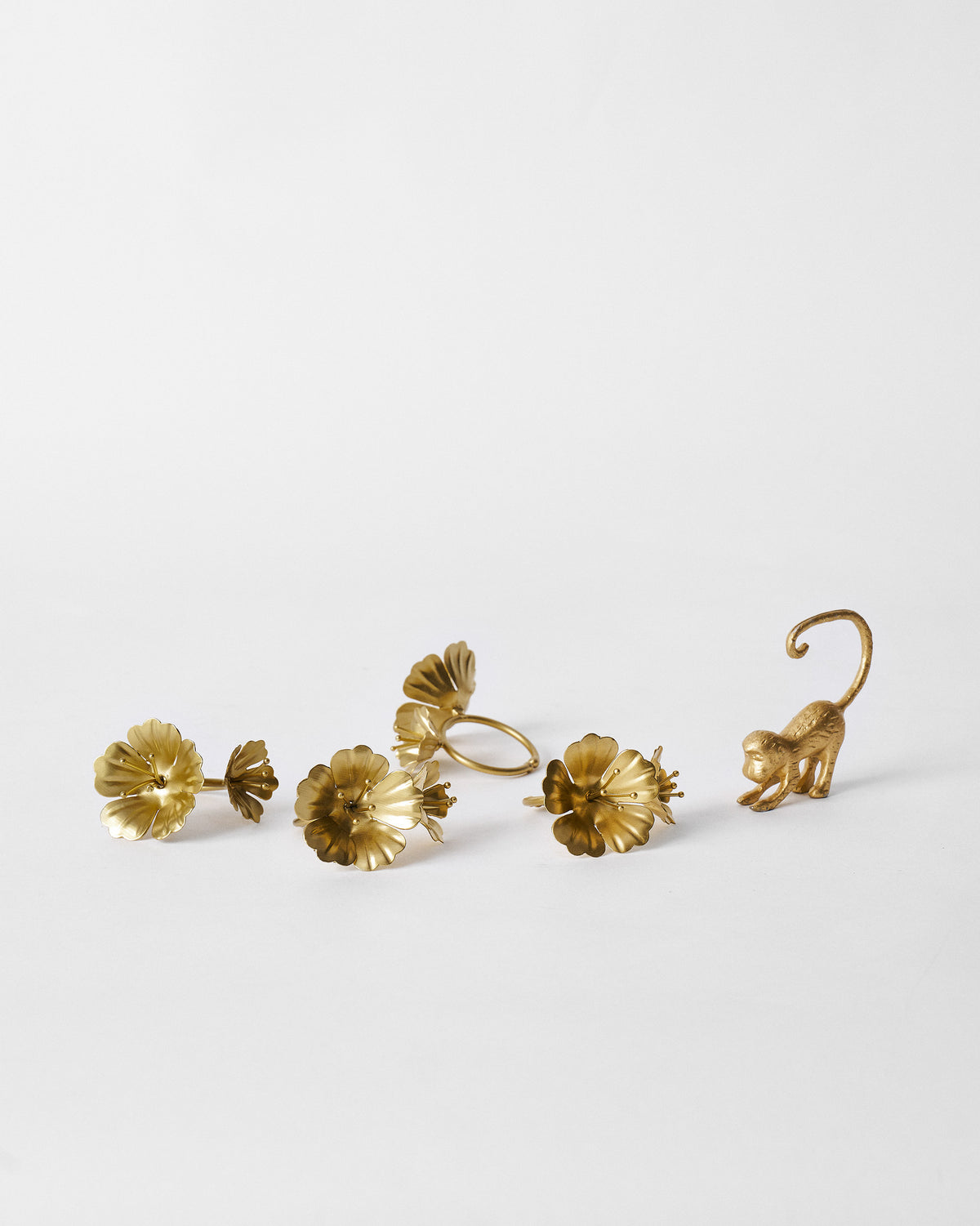 Gold Jungle Table Set pieces: floral napkin rings and a monkey figure.