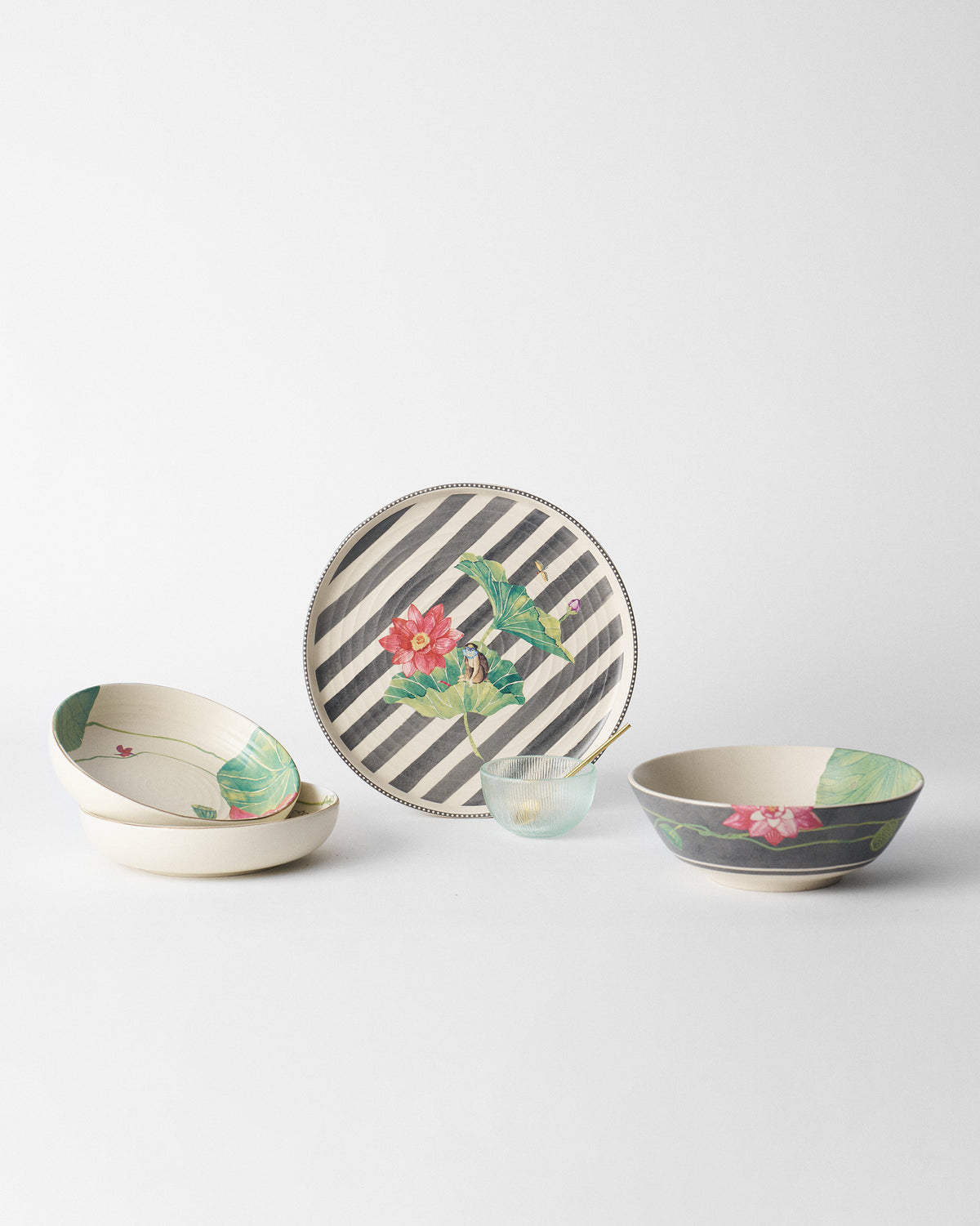 Lotus Garden curry bowl with charcoal lotus exterior beside matching plates.