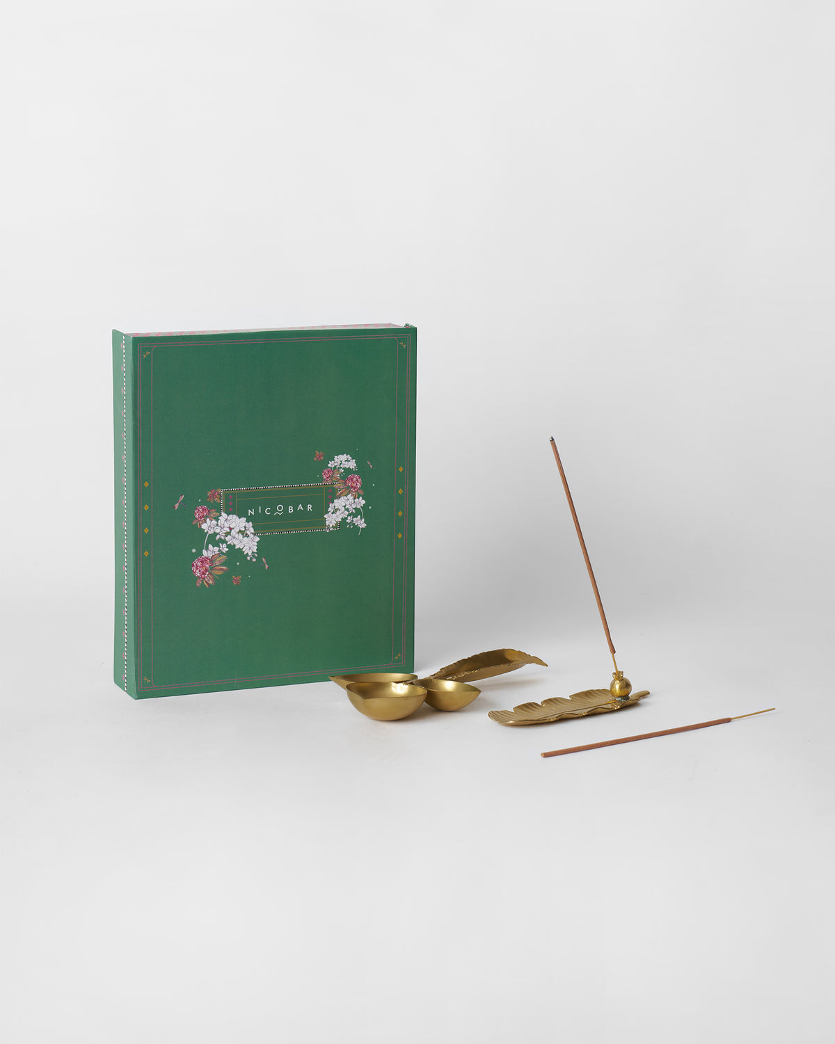 Taal gift set with brass leaf incense holder beside a green gift box.