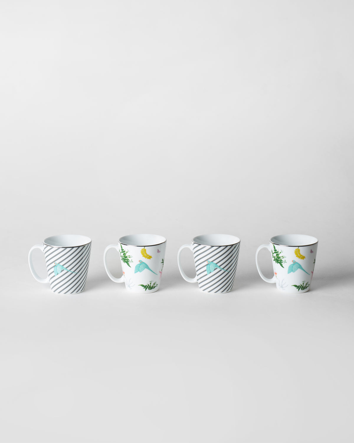 Set of four Botanical Coffee Mugs with striped bird and tropical parrot prints.