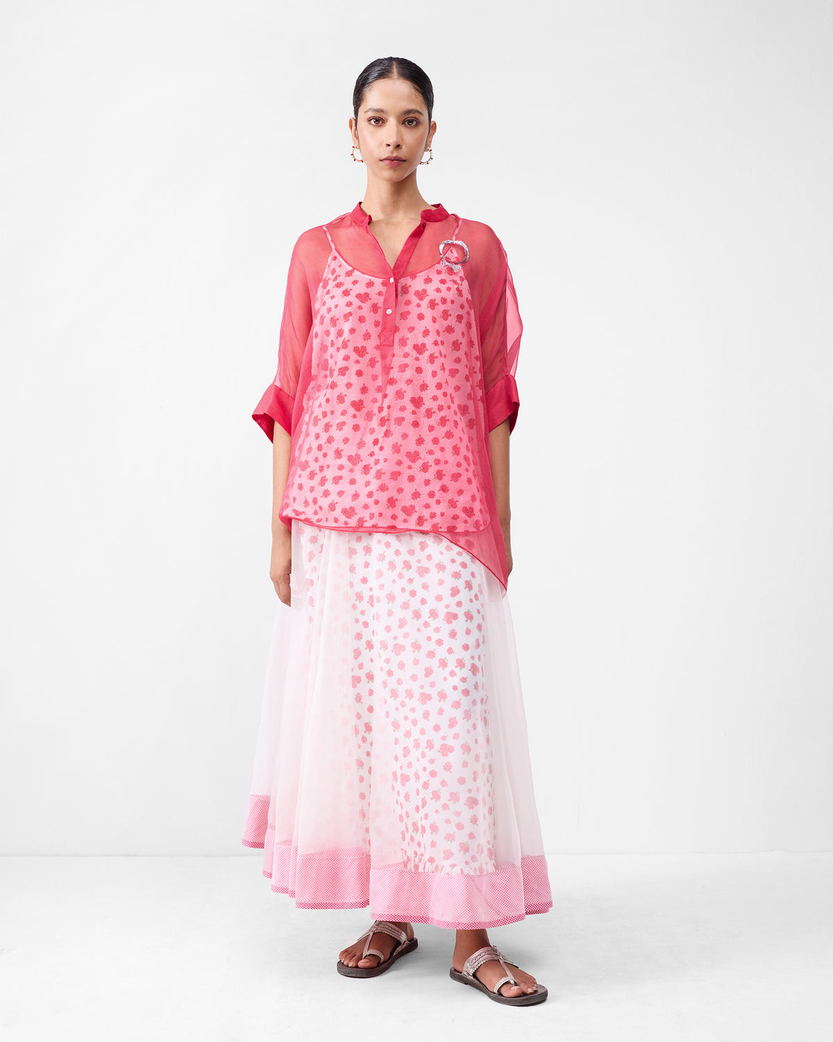 Person wearing a sheer watermelon shirt over a printed slip.