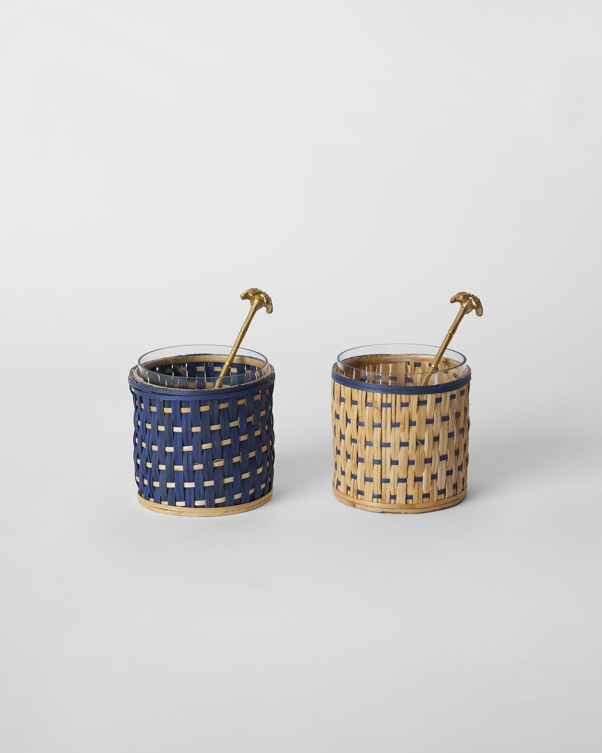 Pair of Bloom condiment jars in navy and natural rattan with brass palm spoons.