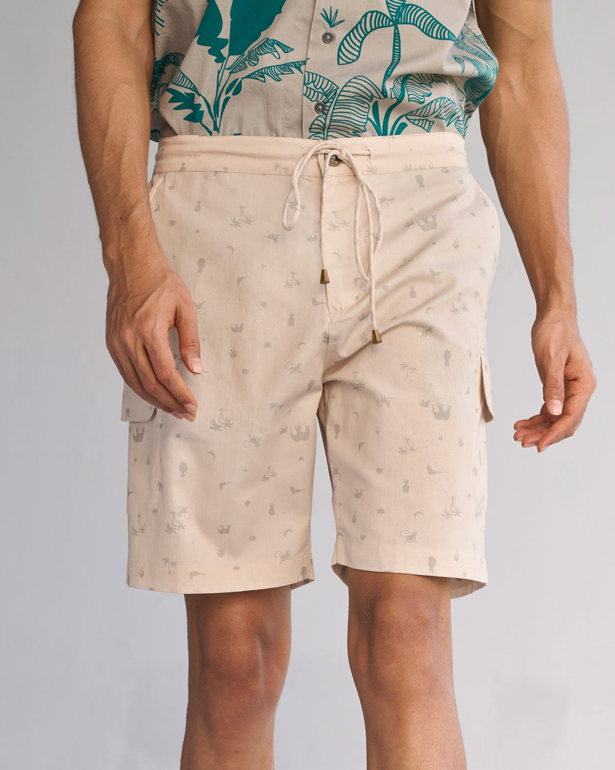 Person wearing beige Luna Shorts with a small grey print and drawstring waist.