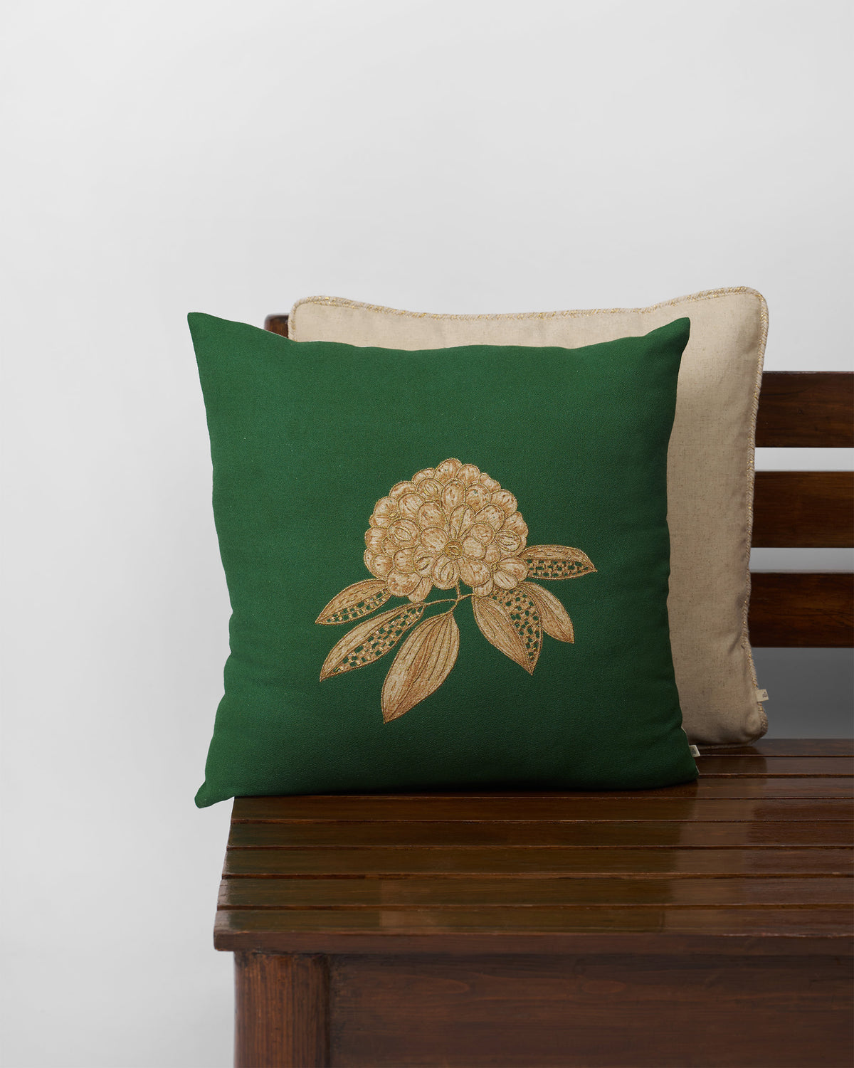 Buransh Bloom Cushion Cover in green with an embroidered gold flower.