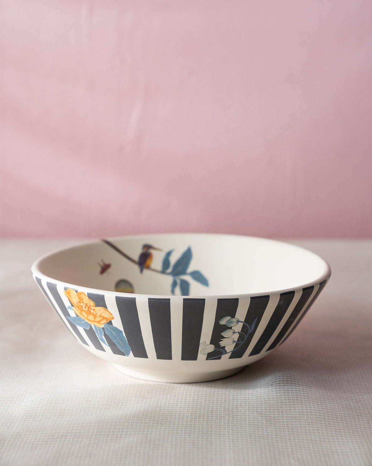 Myra curry bowl with black stripes, an orange flower, and a bird inside.