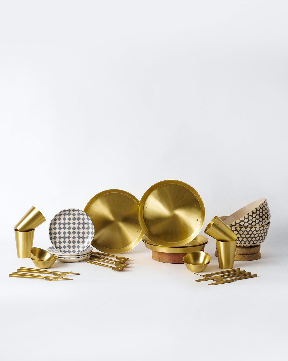 Brass Fez Dinner Set with brass thalis, glasses, cutlery, and patterned ceramics.