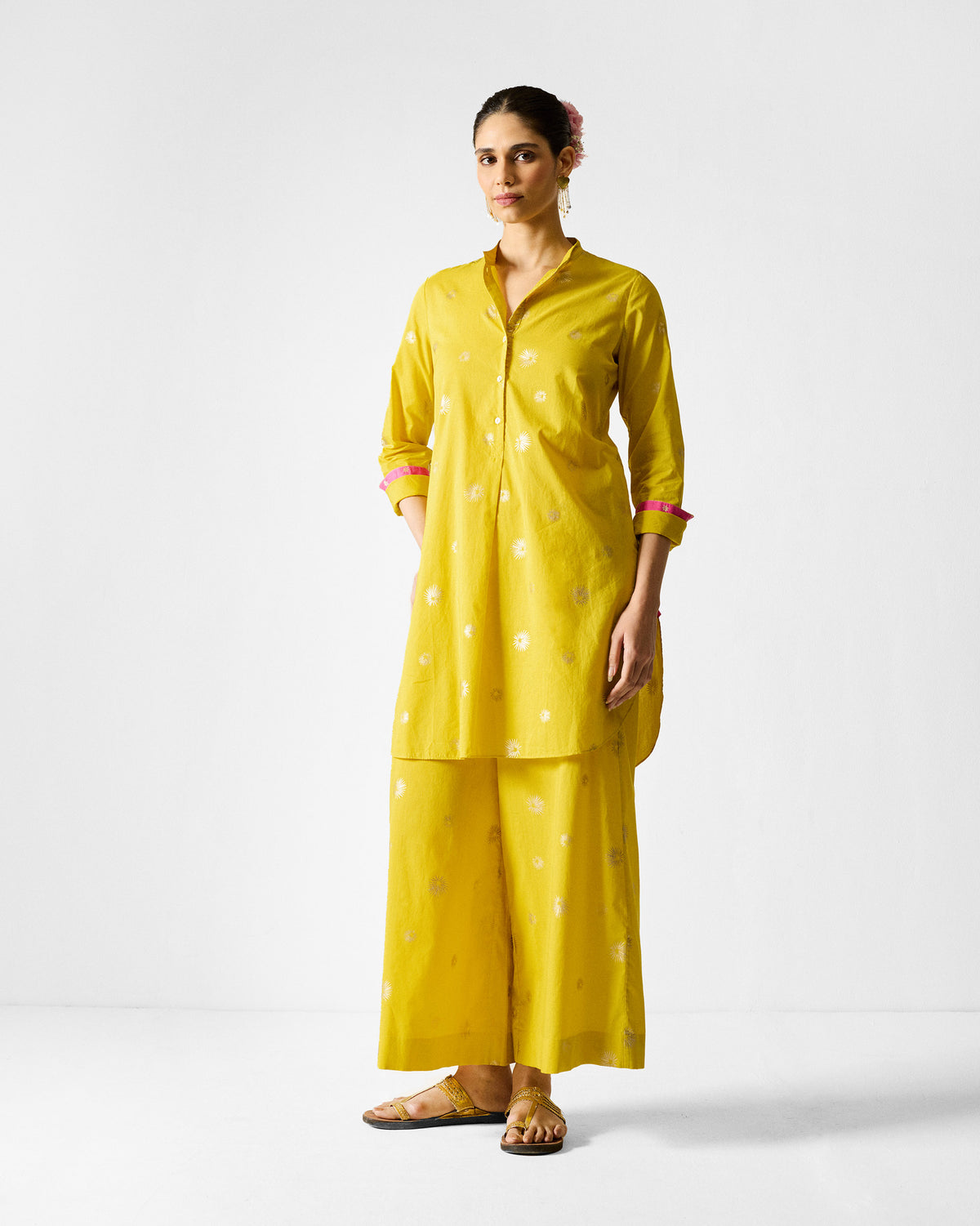 Person wearing the Basic Pyjamas in chartreuse with a band collar and gold print.