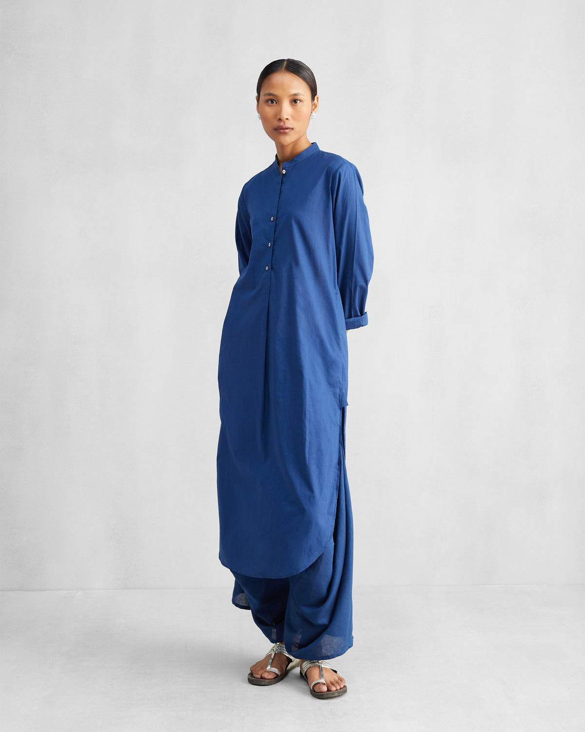 Person wearing a navy long-length kurta set with a mandarin collar and matching trousers.