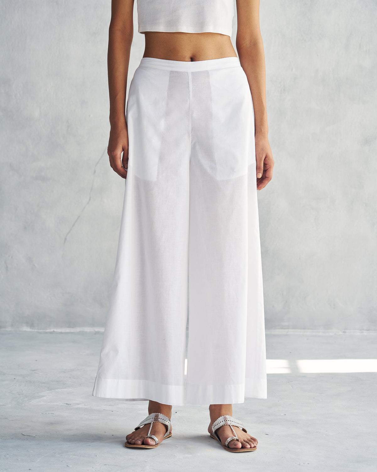 Person wearing the wide white trousers from the Alba set.