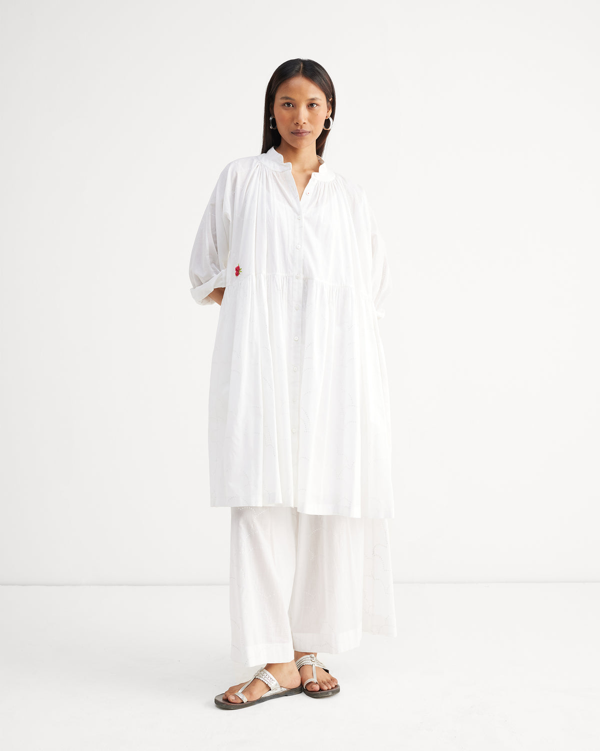 Person wearing white Classic Pyjamas under a loose white tiered top.