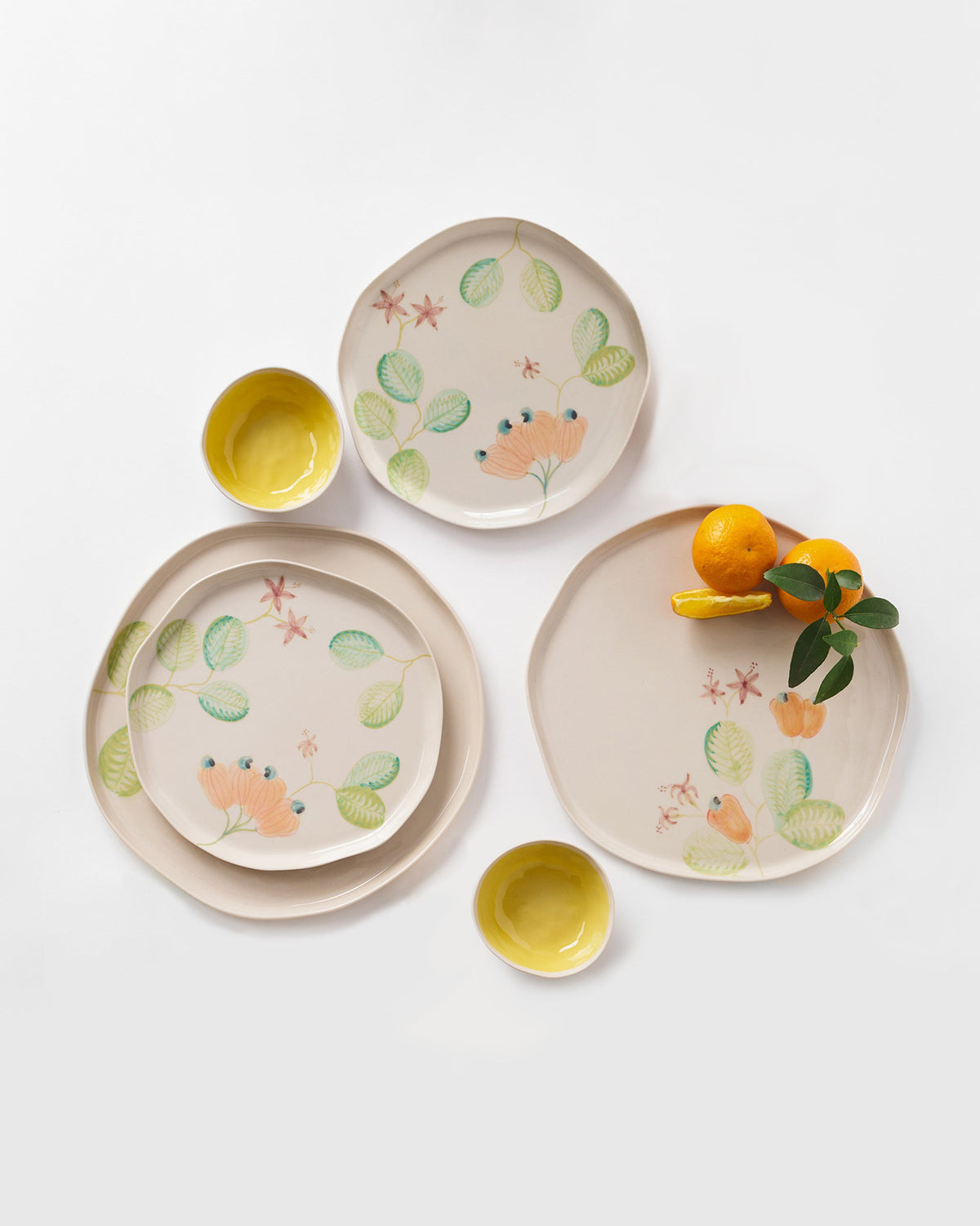 Mandovi dinner set with cream botanical plates and yellow-lined bowls.