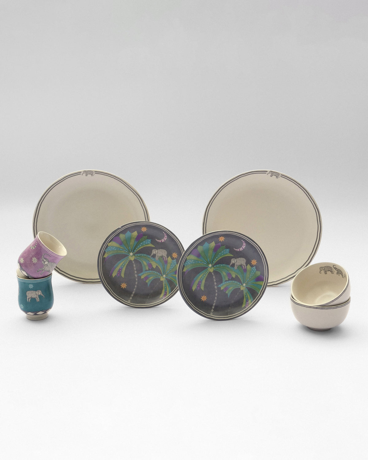 The Tusk Dinner Set for 2 with palm-tree plates and cups and bowls with elephant motifs.