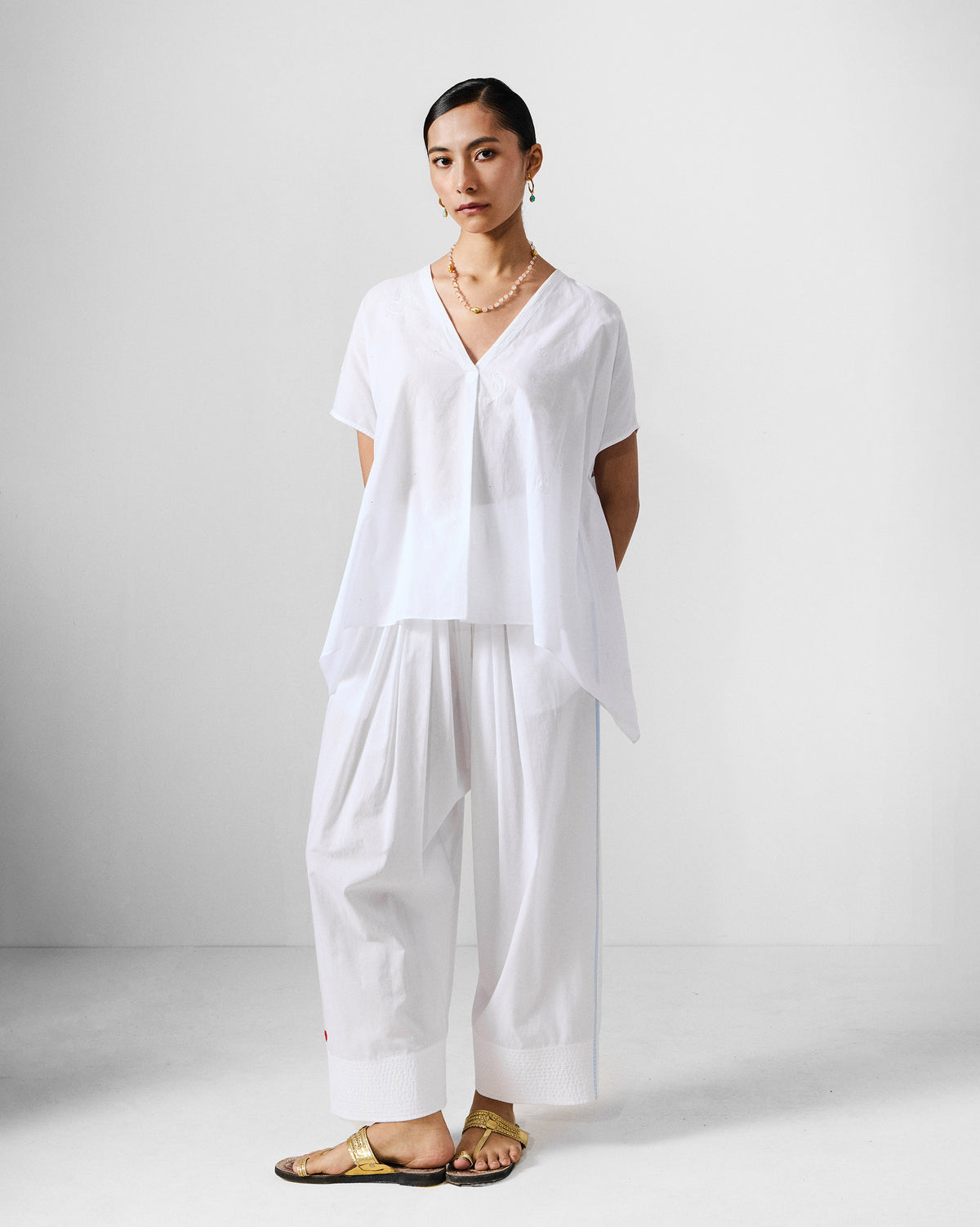 Person wearing an ivory Riva top set with a V-neck top and wide pants.