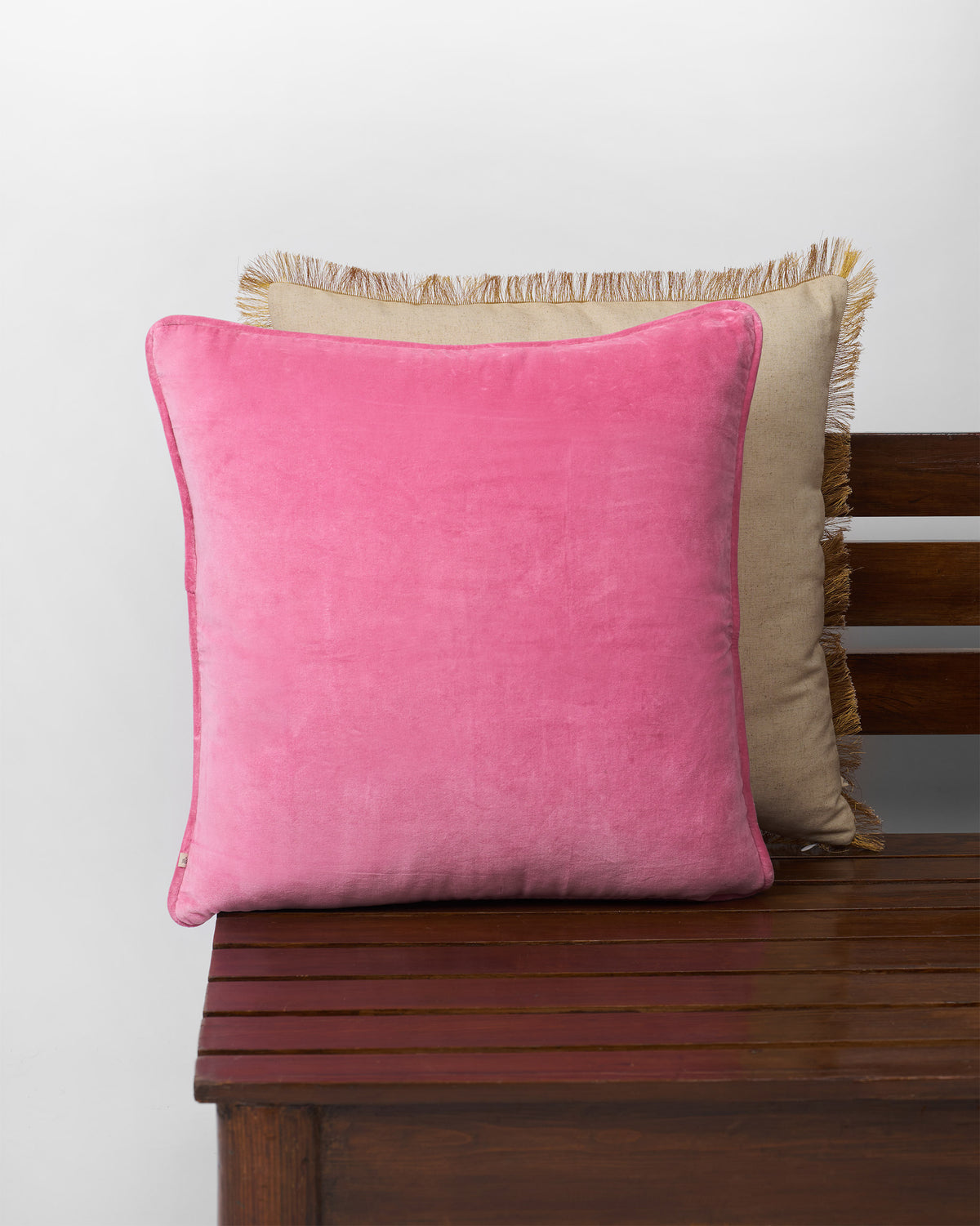 Back of pink Palm Shimmer cushion cover in plain velvet with piping.