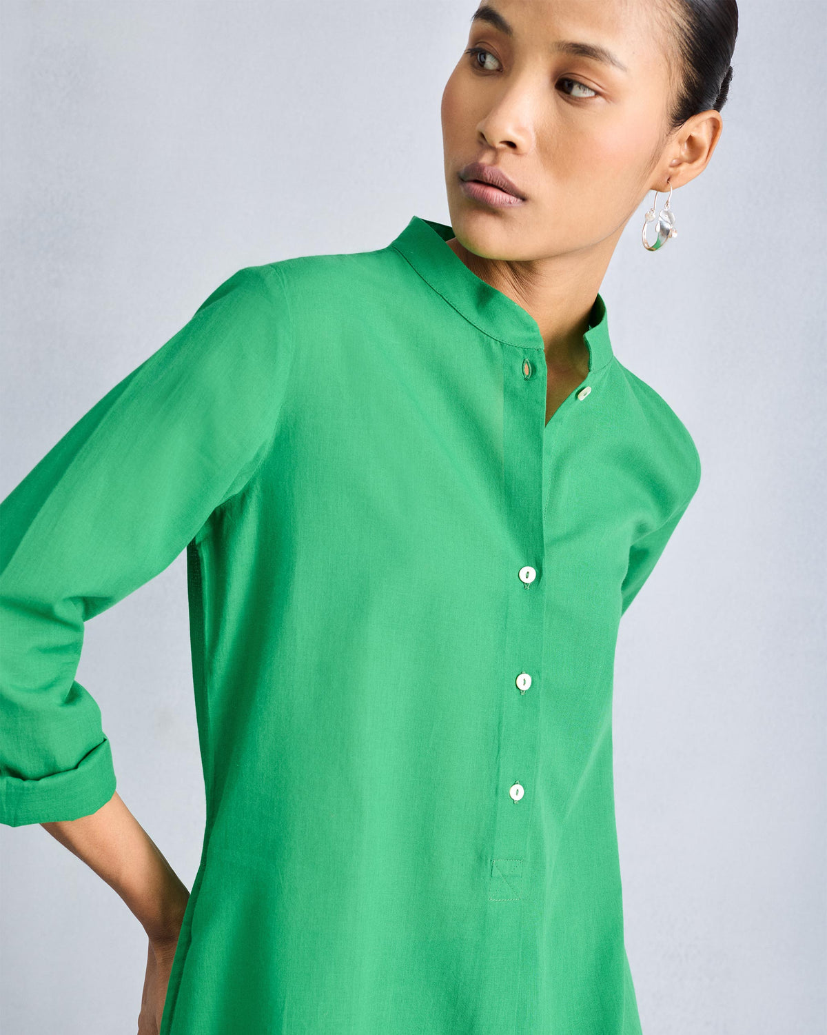 Close-up of a green kurta mandarin collar with a white button placket.