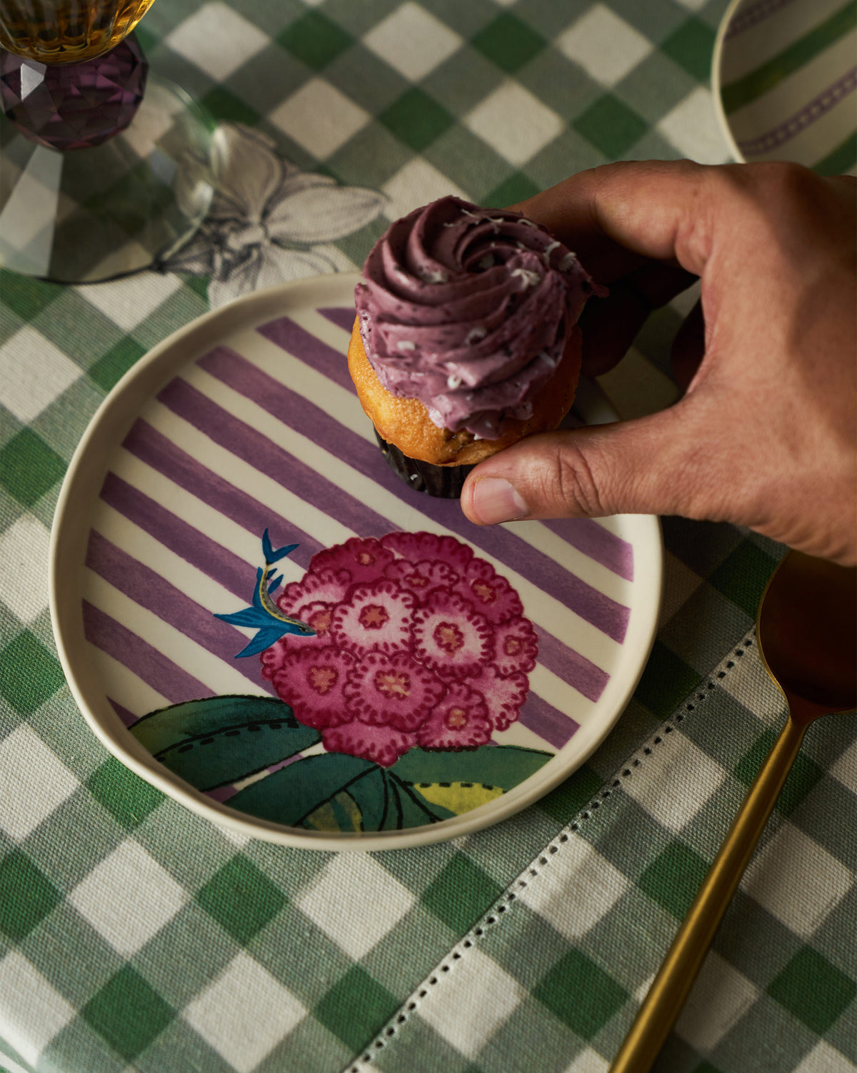 Buransh dessert plate holding a cupcake with purple frosting.