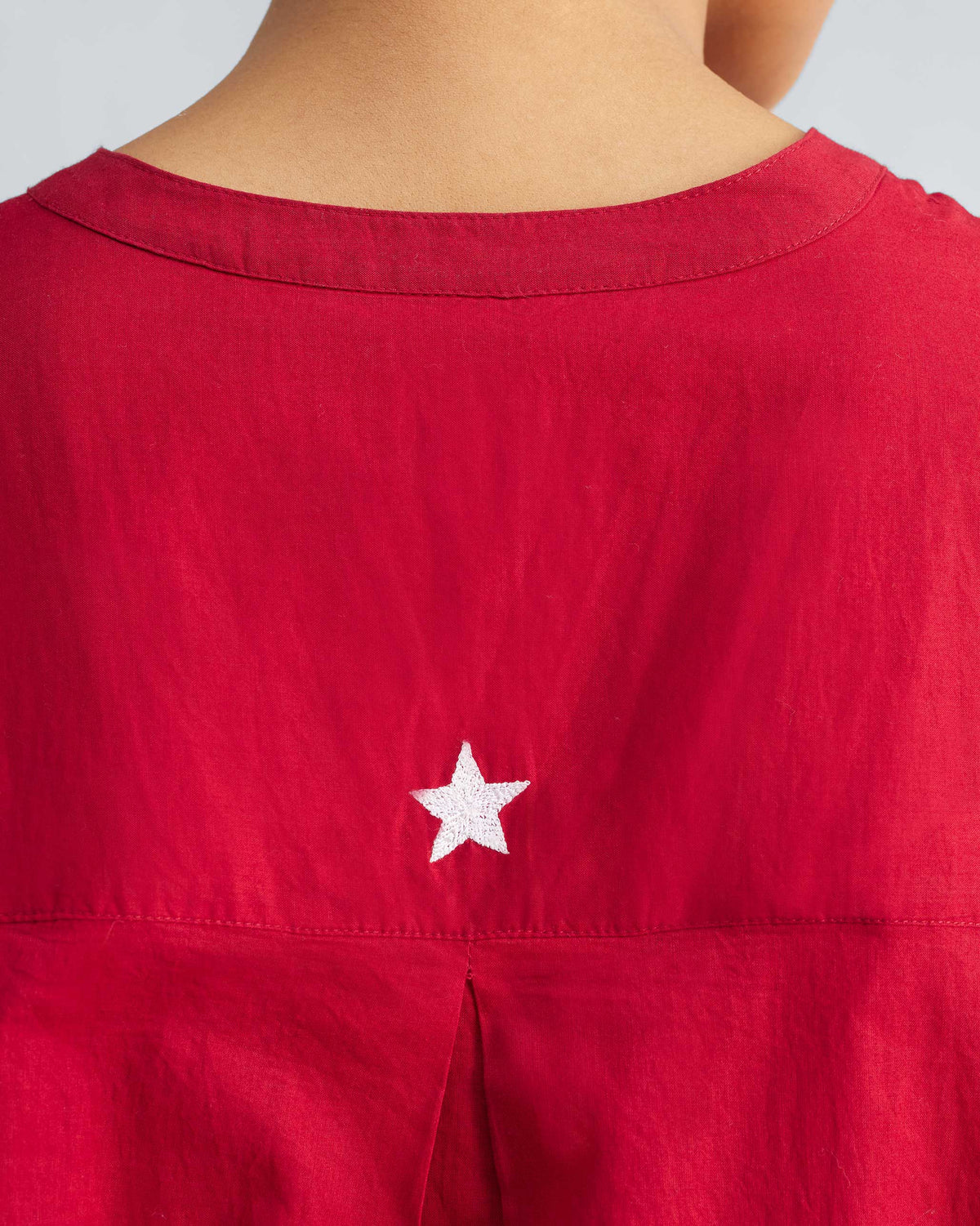 Close-up of the white star embroidery on a red Lazy Sunday tunic.