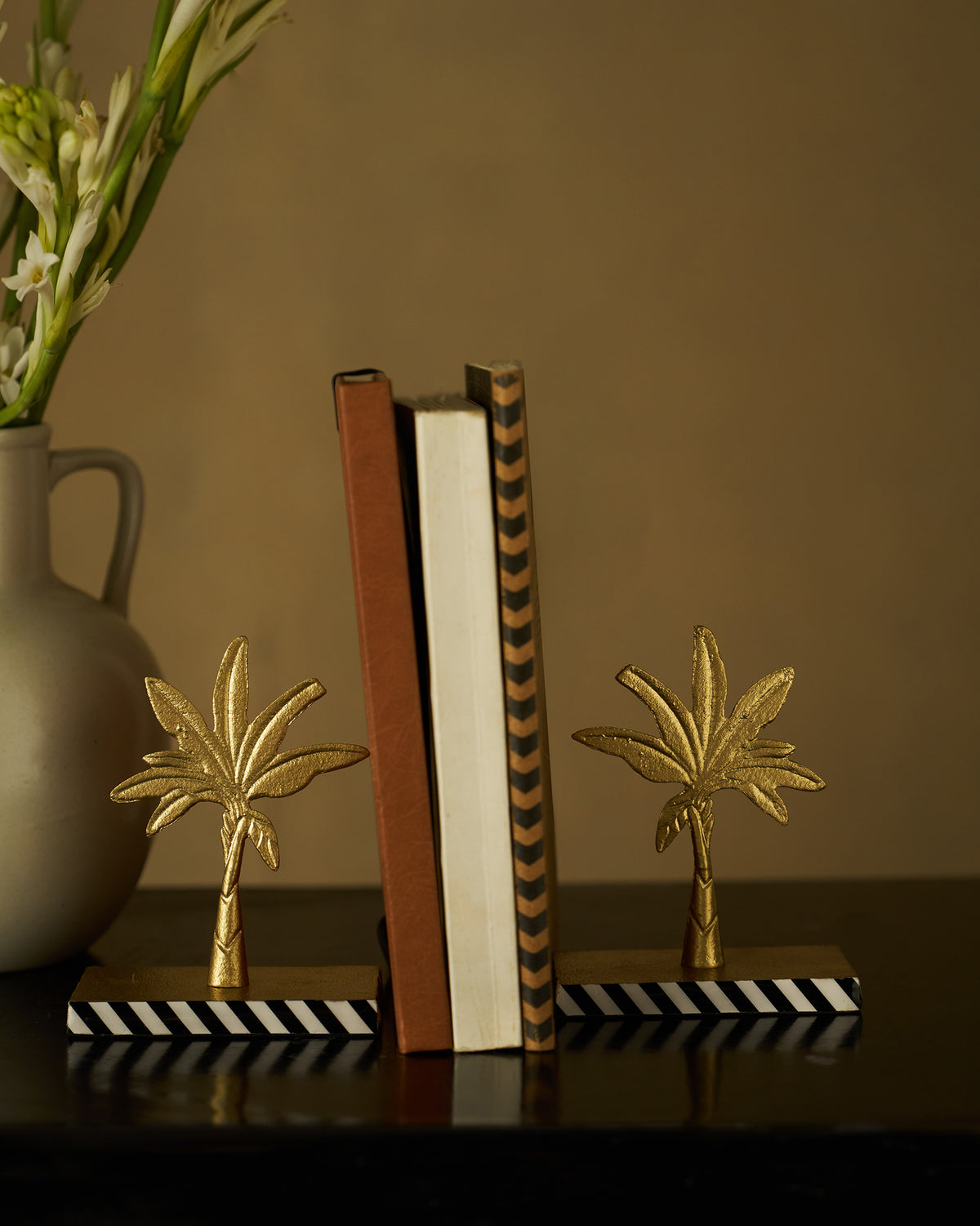 Gilded Palm bookends with gold palms holding a short row of books upright.