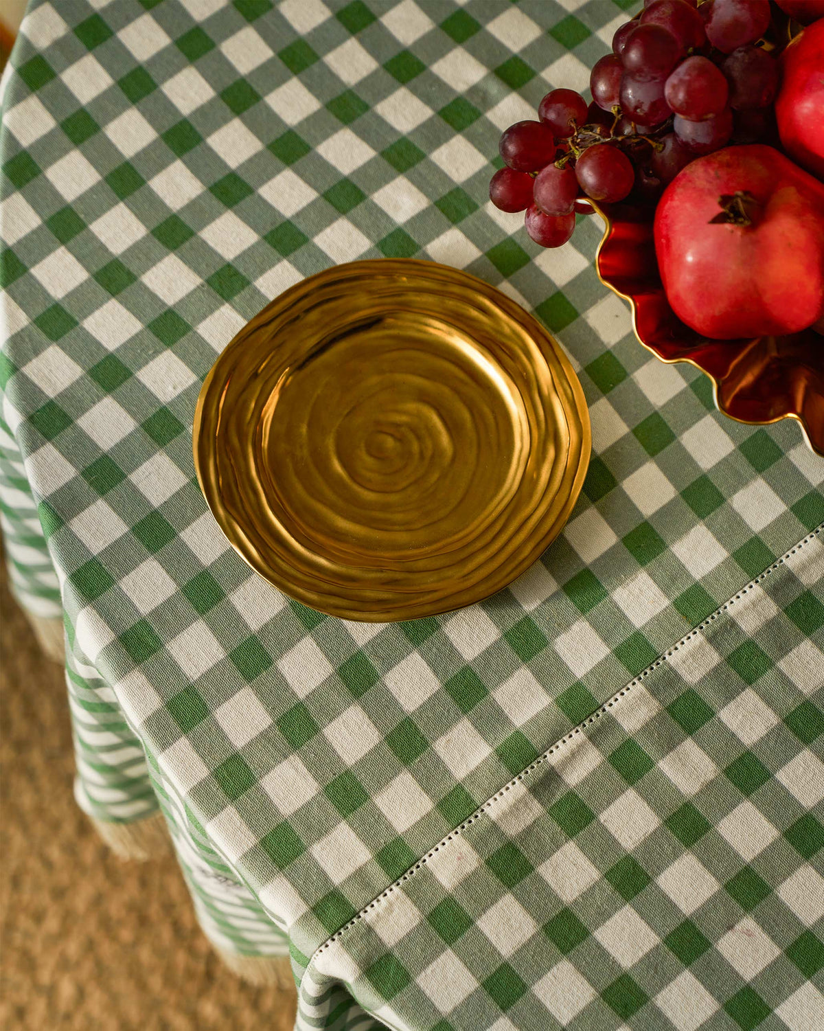 Dhaara Quarter Plate in gold on a green checked tablecloth.