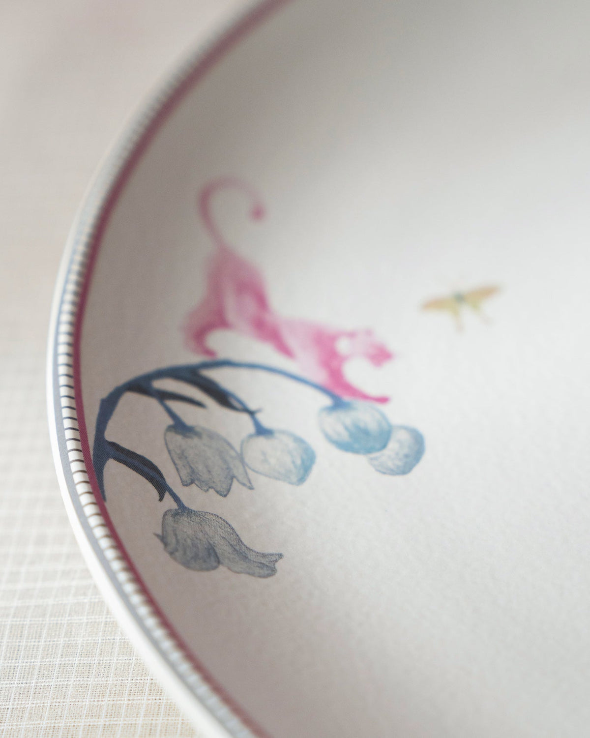 Close-up of a Myra plate with a pink tiger and blue flowers.