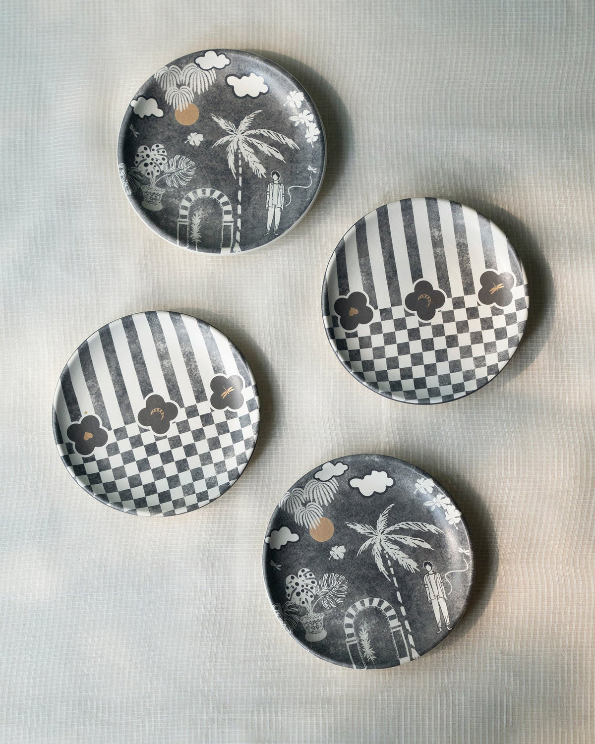 Four Moonlight tea plates in tropical scene and checkered stripe designs.