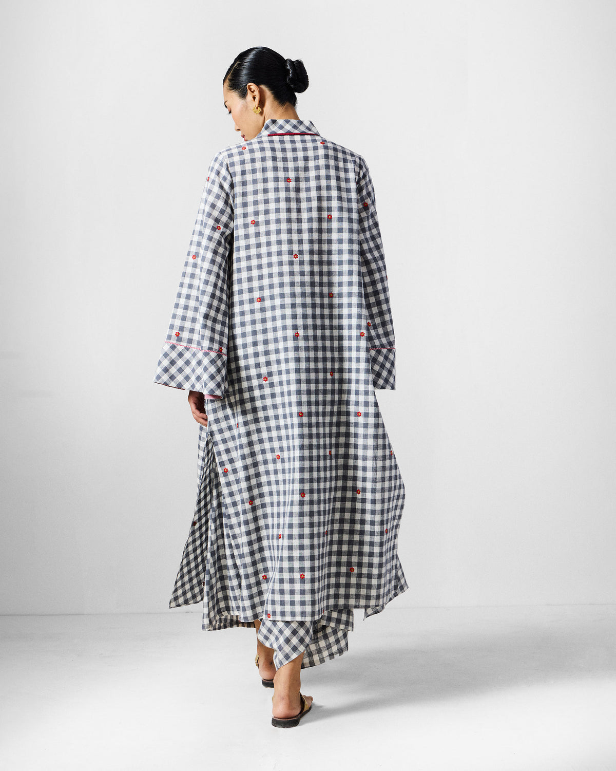 Back of a grey and white check kurta set with red embroidery.