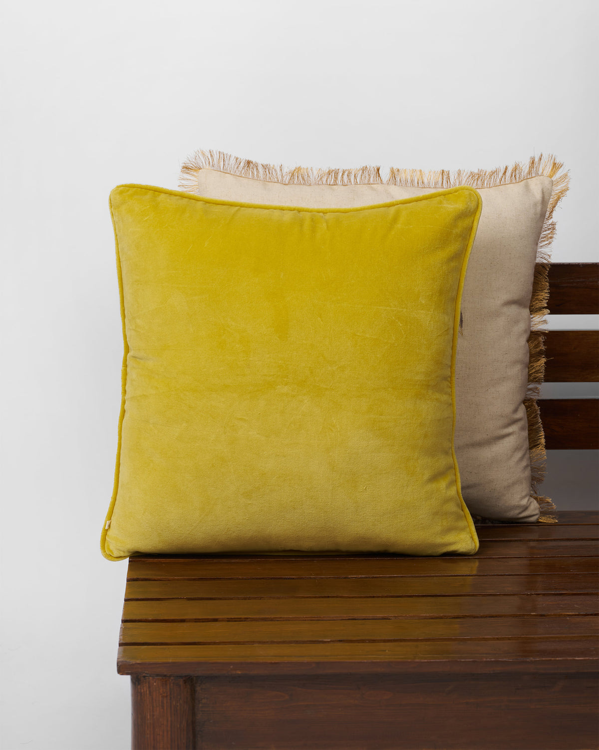 Back of yellow Palm Shimmer cushion cover in plain velvet with piping.