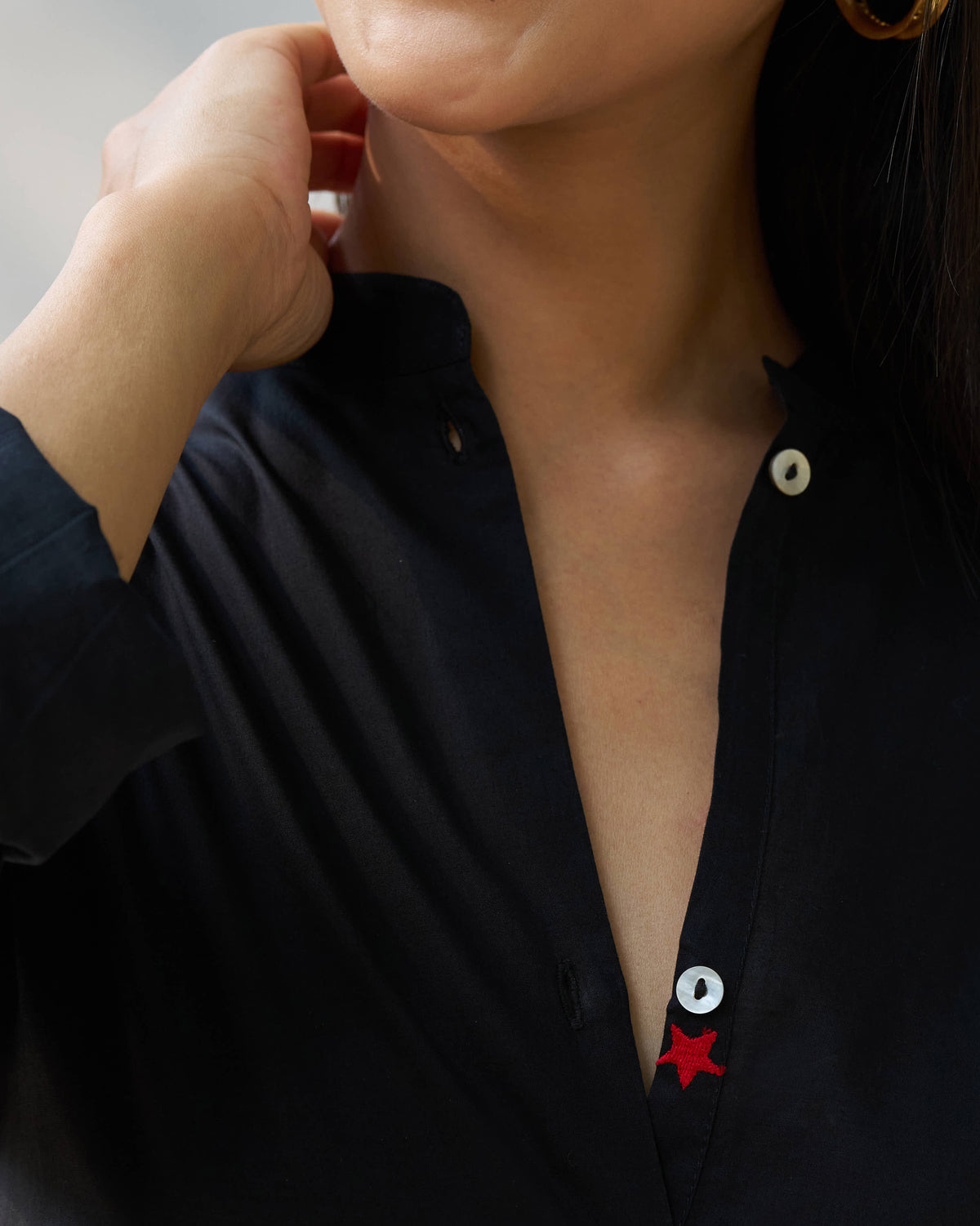 Close-up of a black Stone set collar with a red star on the placket.