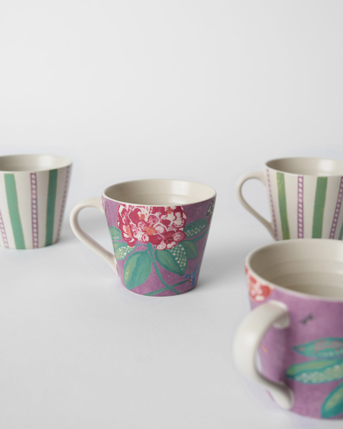 Buransh Espresso Mugs grouped to show purple blooms and green stripes.