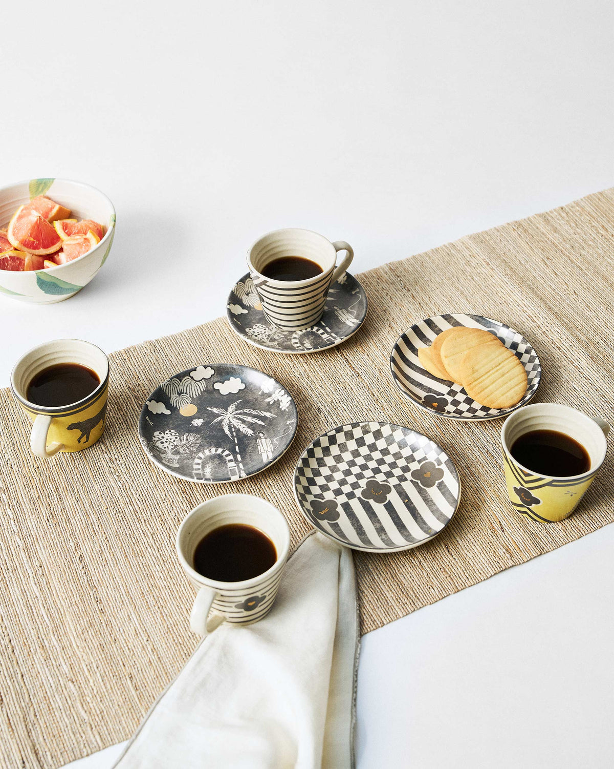 Moonlight tea set with yellow leopard mugs and patterned plates in use.