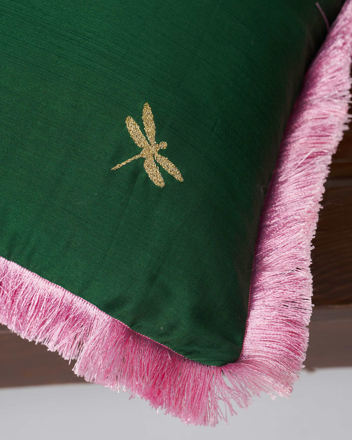 Close-up of Kinaara Cushion Cover in green showing a gold dragonfly and pink fringe.