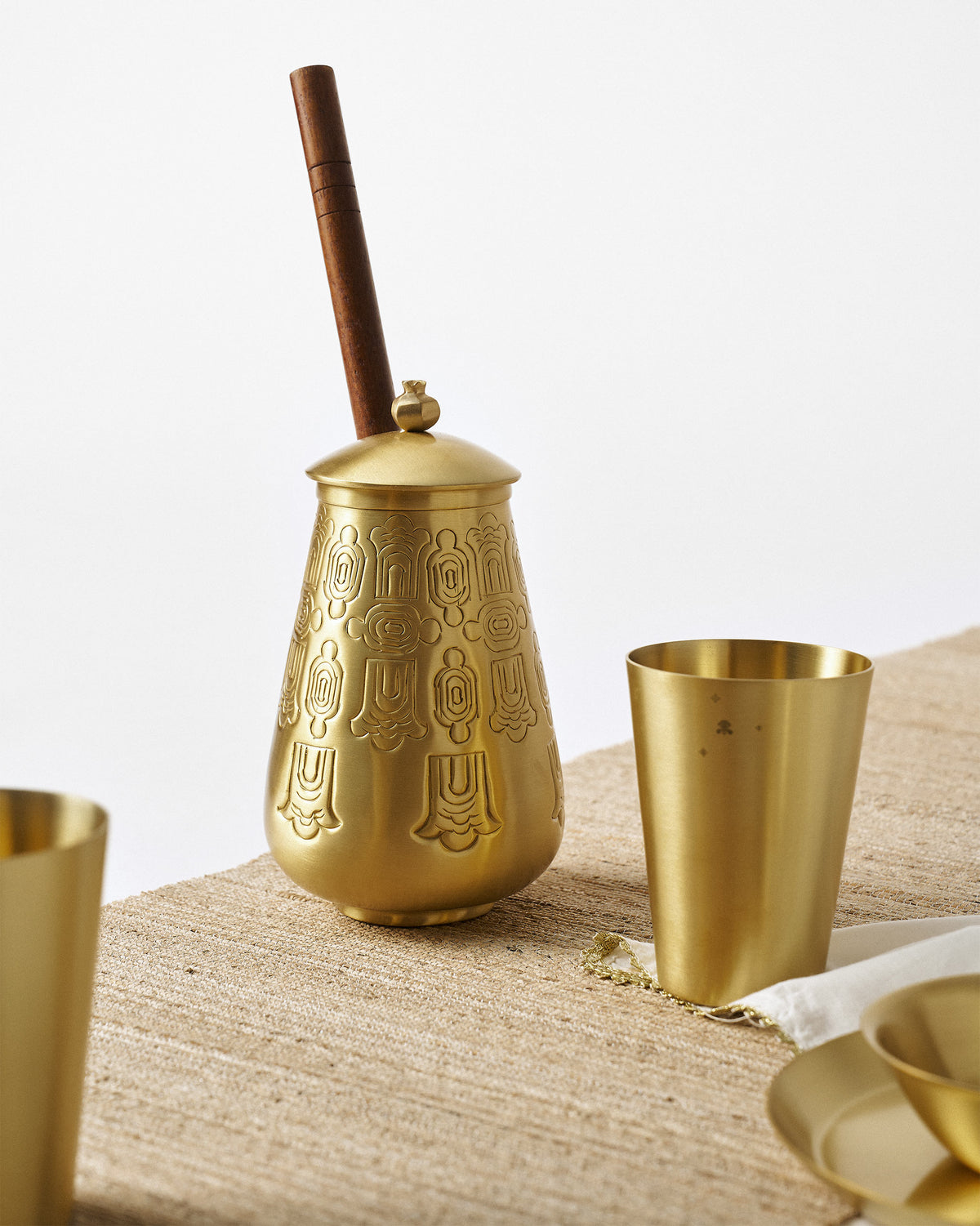 Heritage Churn Set with a brass churner, tumbler, and bowl on a table runner.