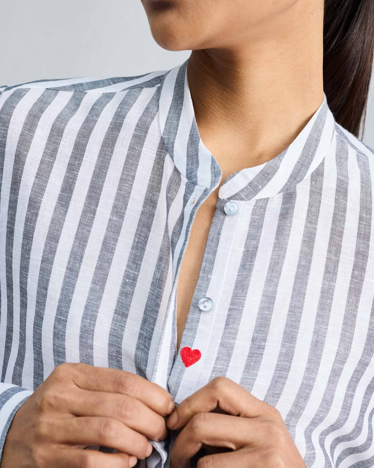 Close-up of the Mandarin Collar shirt's placket showing a small red heart embroidered below the buttons.