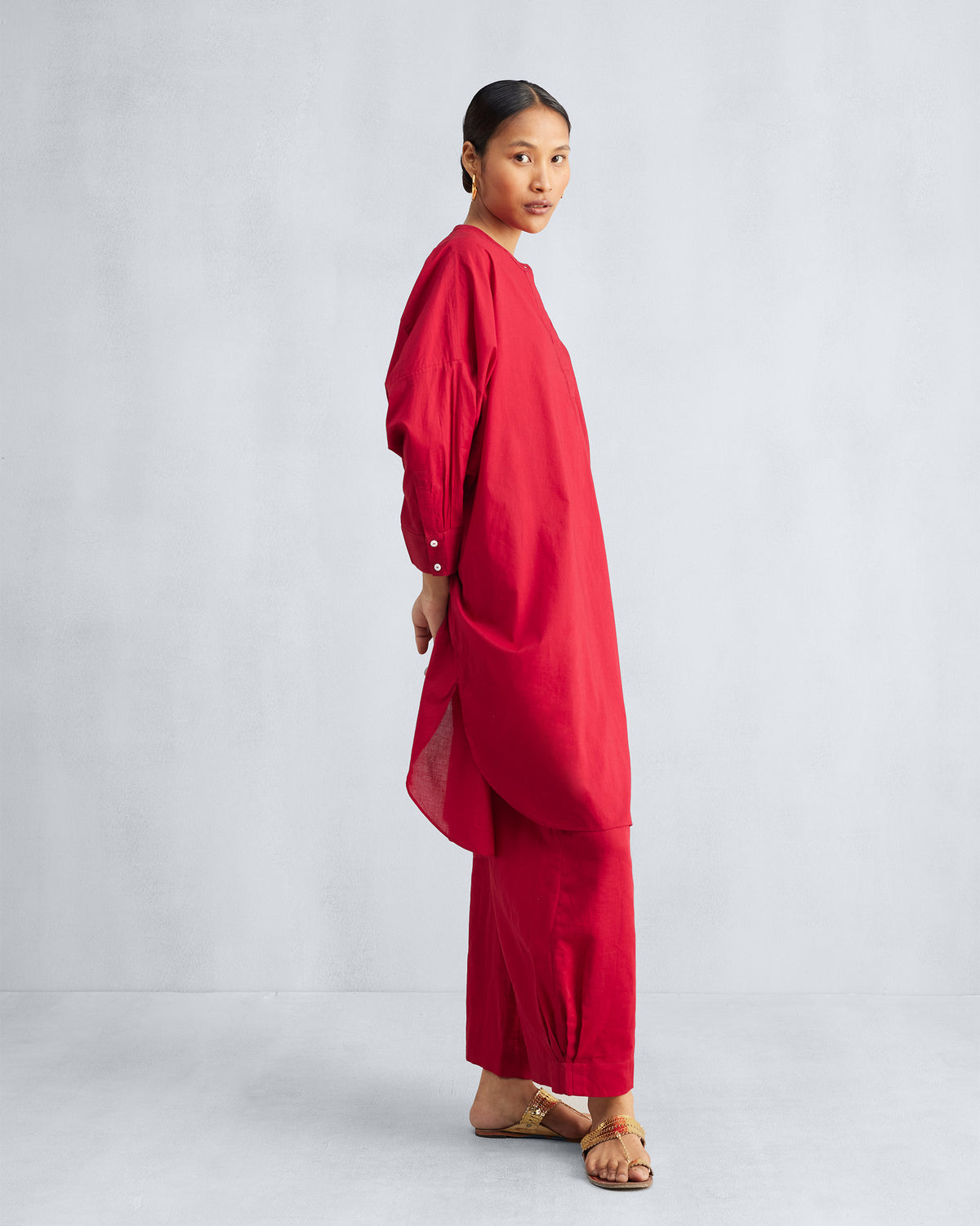 Side view of a red Lazy Sunday tunic set with a curved high-low hem.