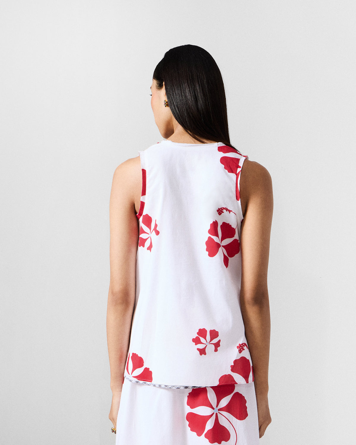 Back of the Kiva top worn by a person, in white with scattered red floral print.