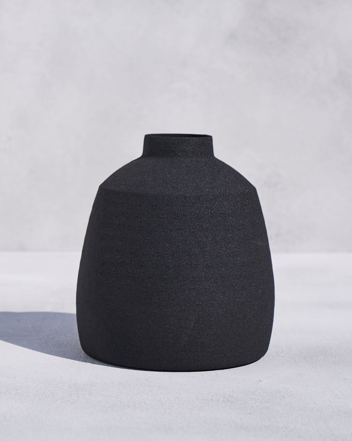 Shorter Midnight vase in matte black with a textured rounded body.