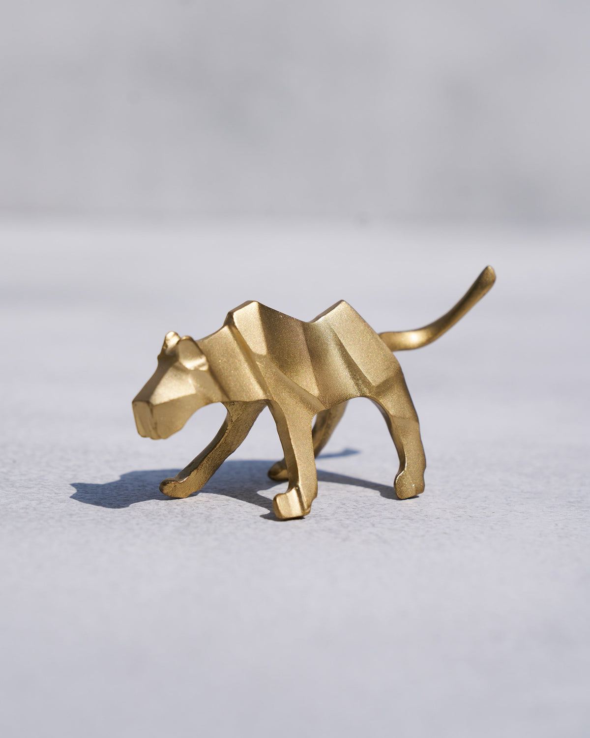 Side view of the gold tiger figurine from the Tiger Rakhi Set.