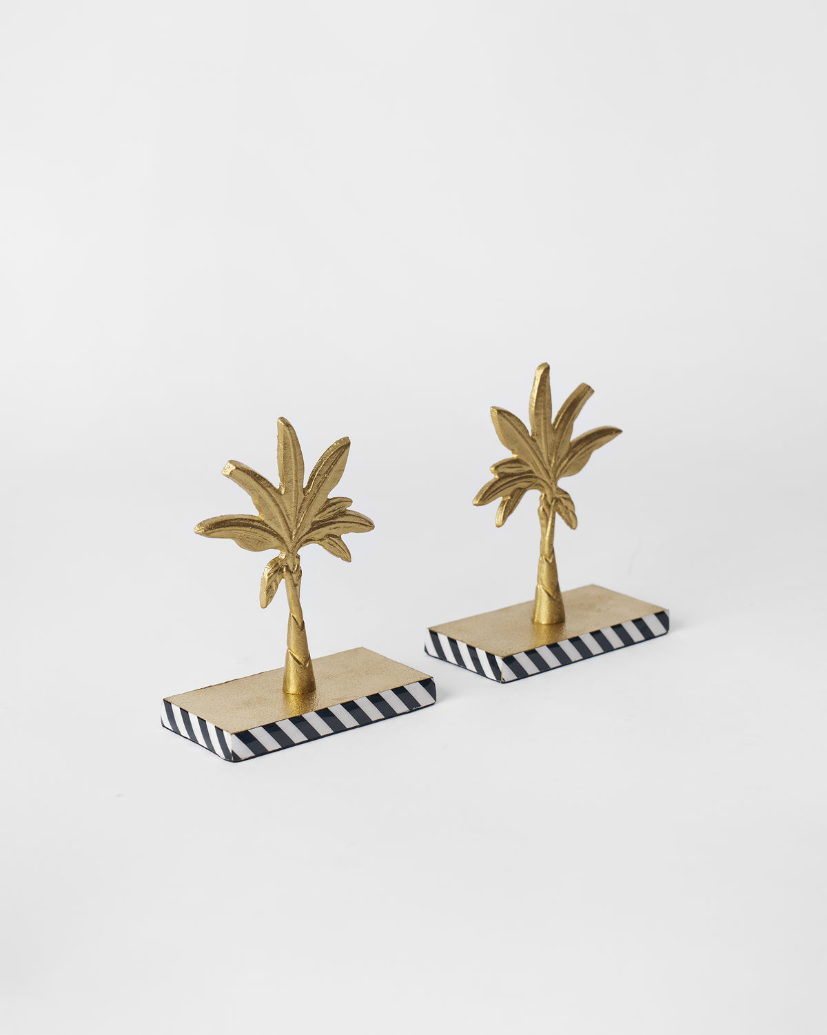 Angled view of Gilded Palm bookends showing gold fronds and striped bases.