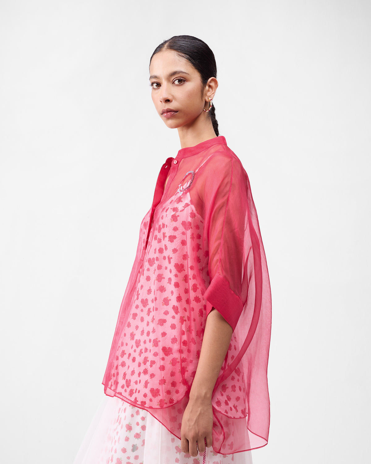 Side view of a sheer watermelon Desert Bloom shirt over an ivory floral underlayer.