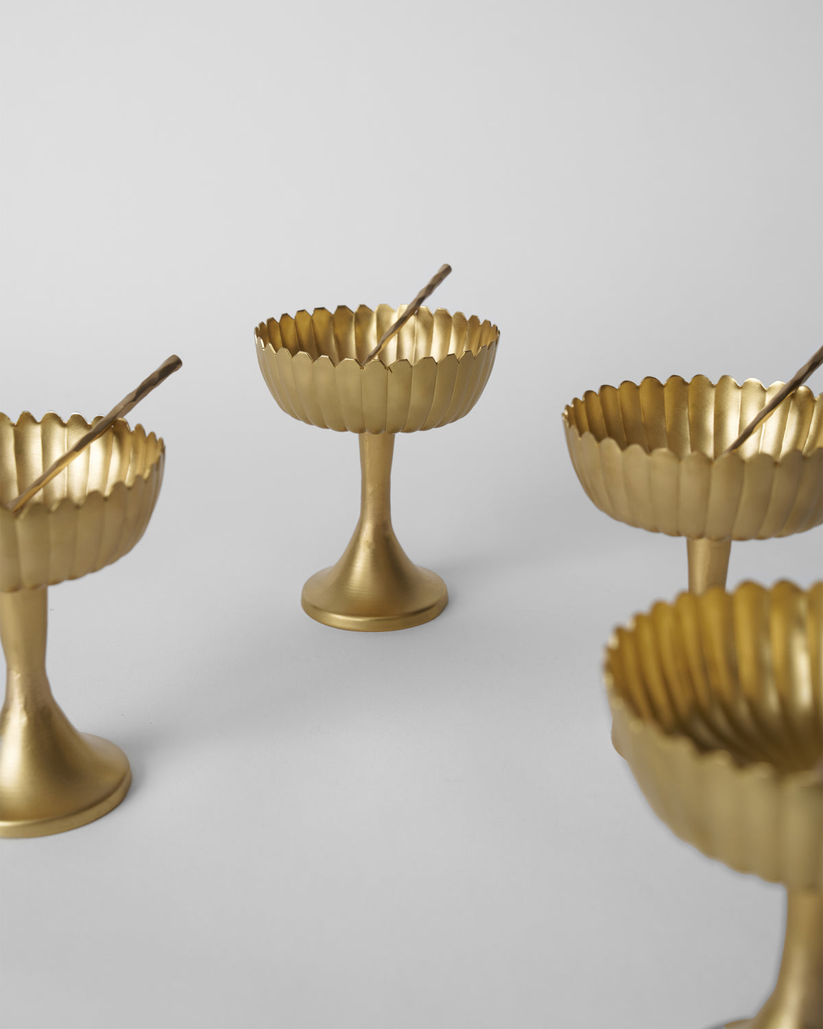 Gold Dhaara Gelato Cups with scalloped rims on slender pedestals.