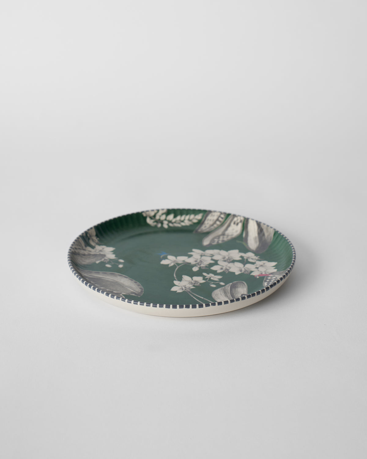 Side view of Reesha Quarter Plate - Green showing its raised rim and white flower print.