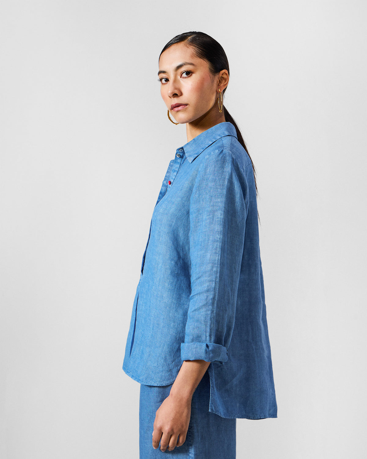 Side view of a blue Mati shirt with a high-low hem.