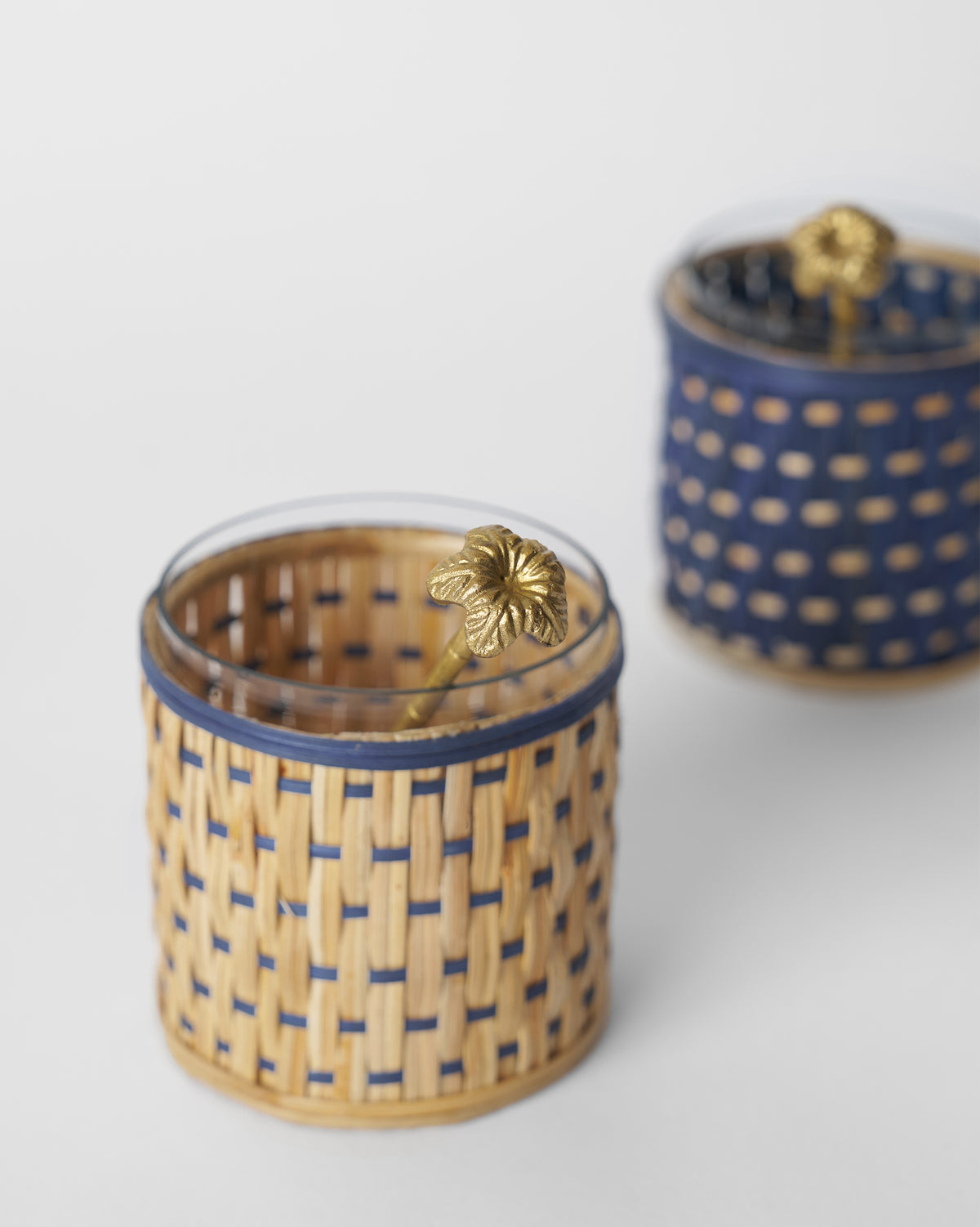 Close-up of a Bloom rattan condiment jar with a brass flower-topped spoon.