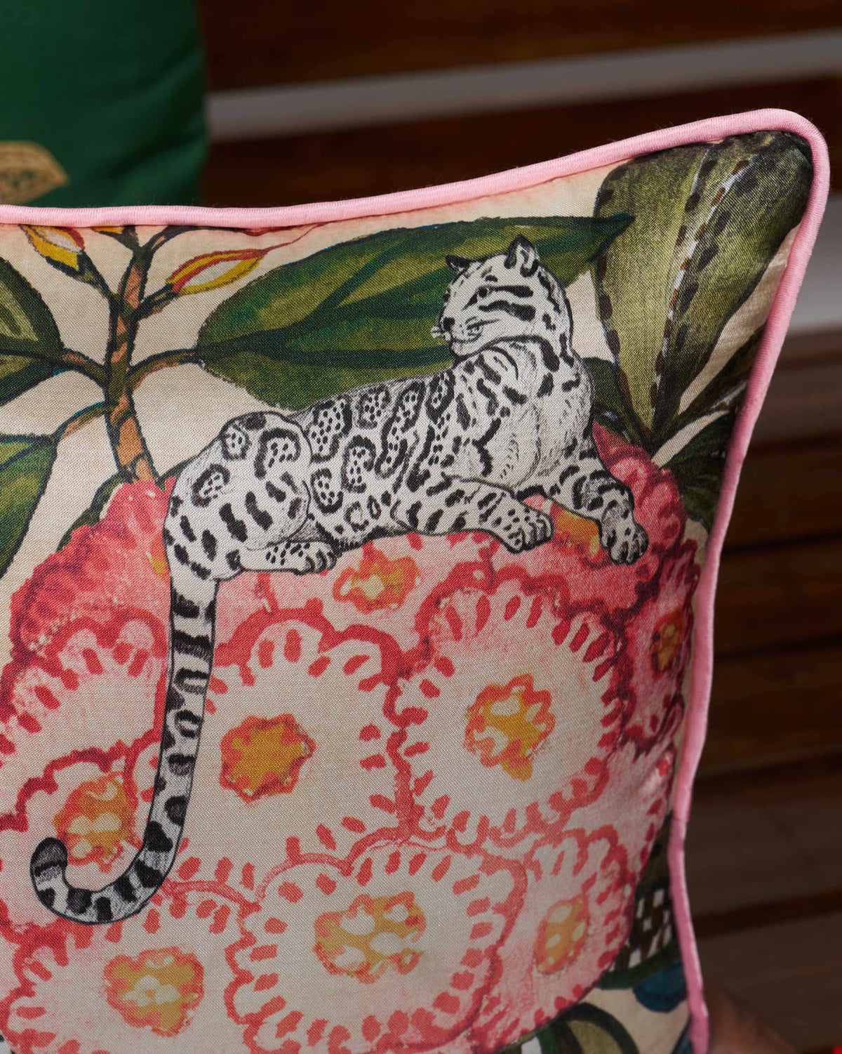 Close-up of Buransh Cushion Cover showing a spotted cat on pink blooms.