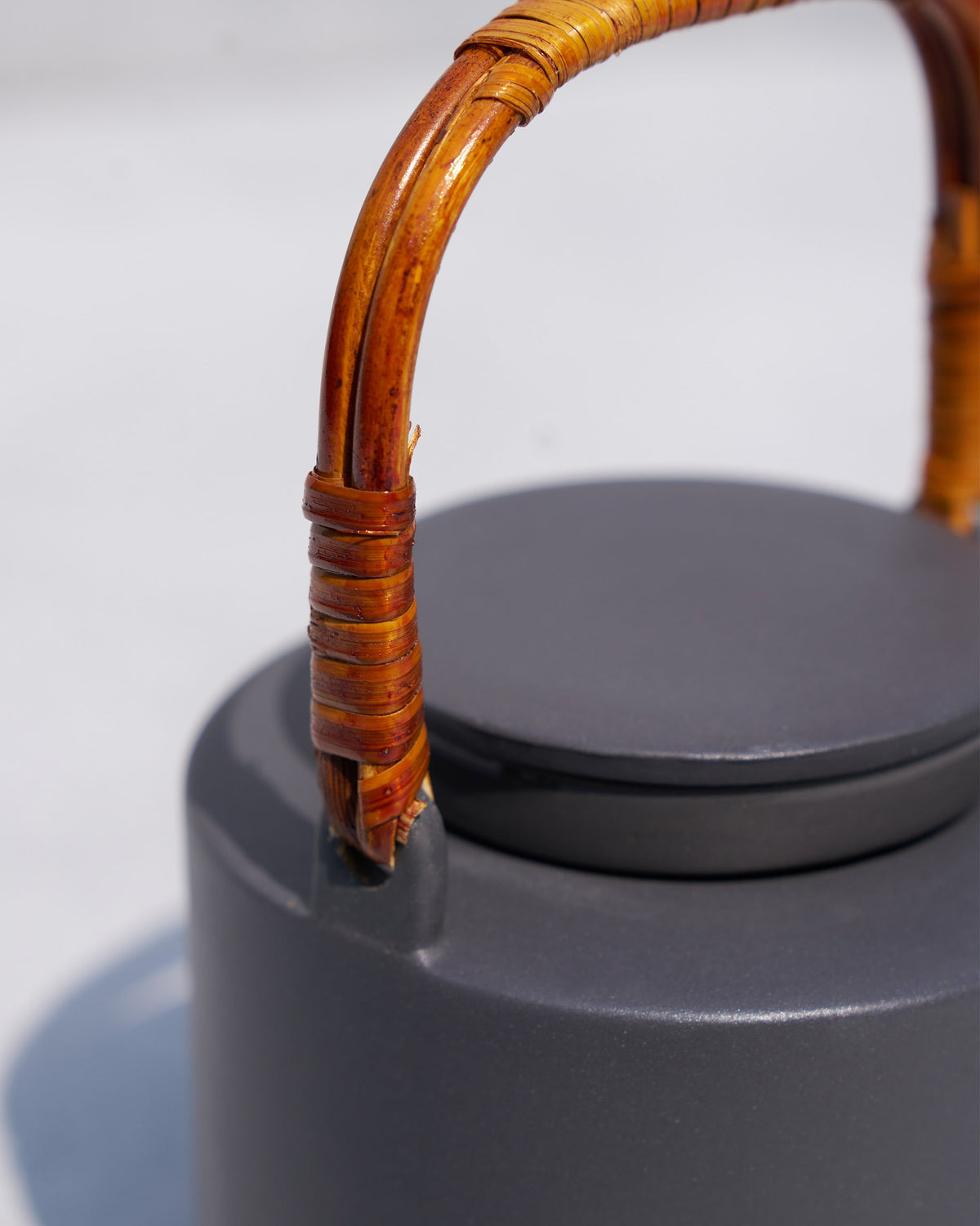 Close-up of the Taramandal teapot rattan handle and charcoal lid.