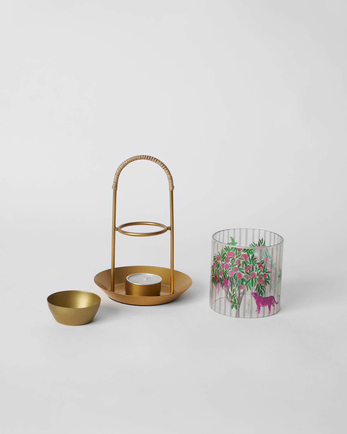 Kandy diffuser parts laid out: oil bowl, gold stand and glass sleeve.